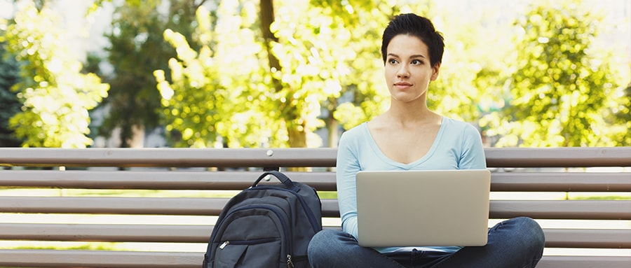 Student writing a college essay on a laptop