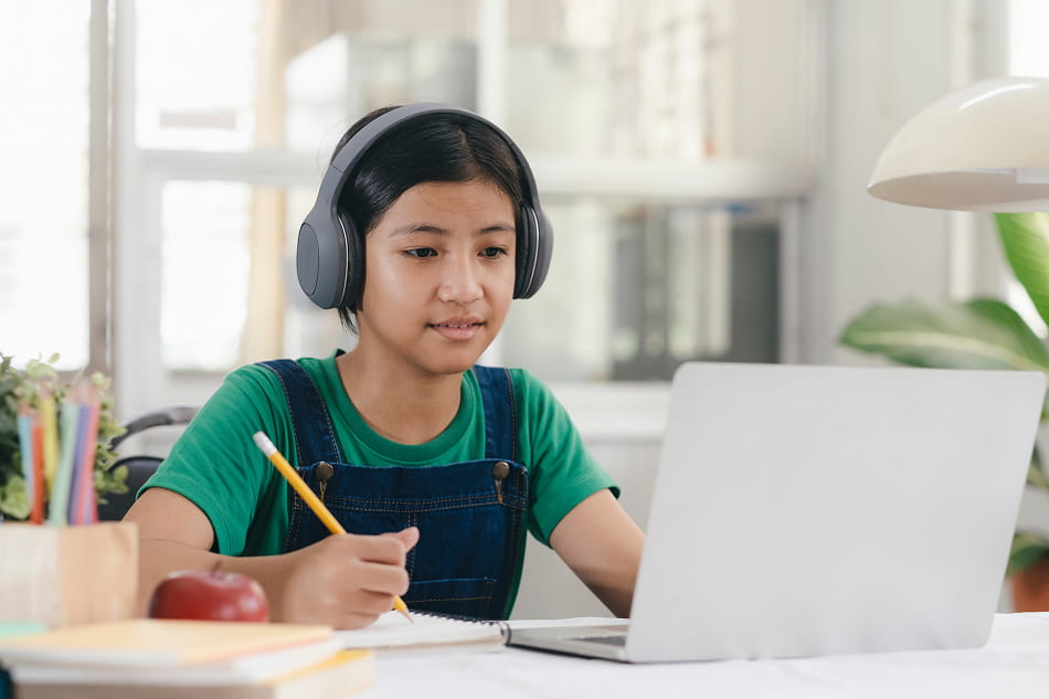 Young student taking notes with laptop