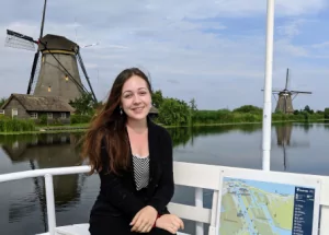 Woman sitting in front of windmills on a boat
